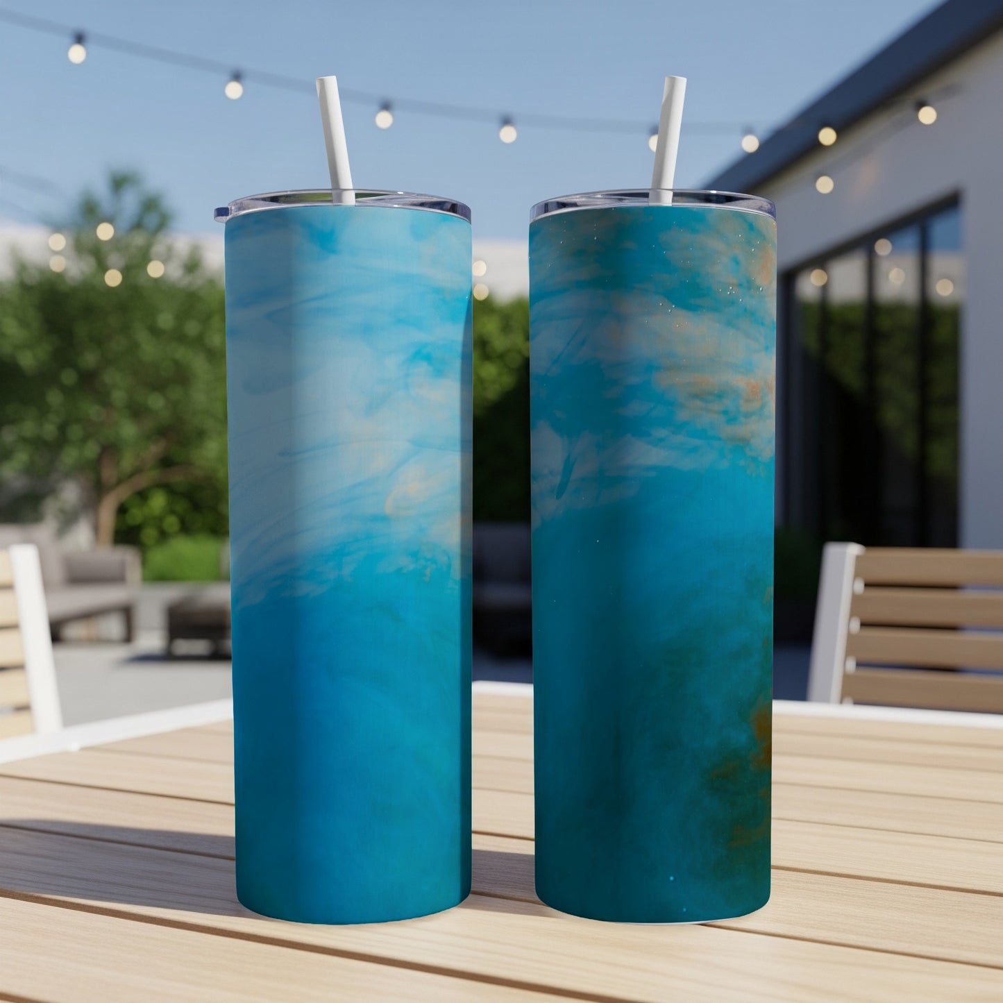 Two blue tumblers with abstract watercolor designs sit on a table.