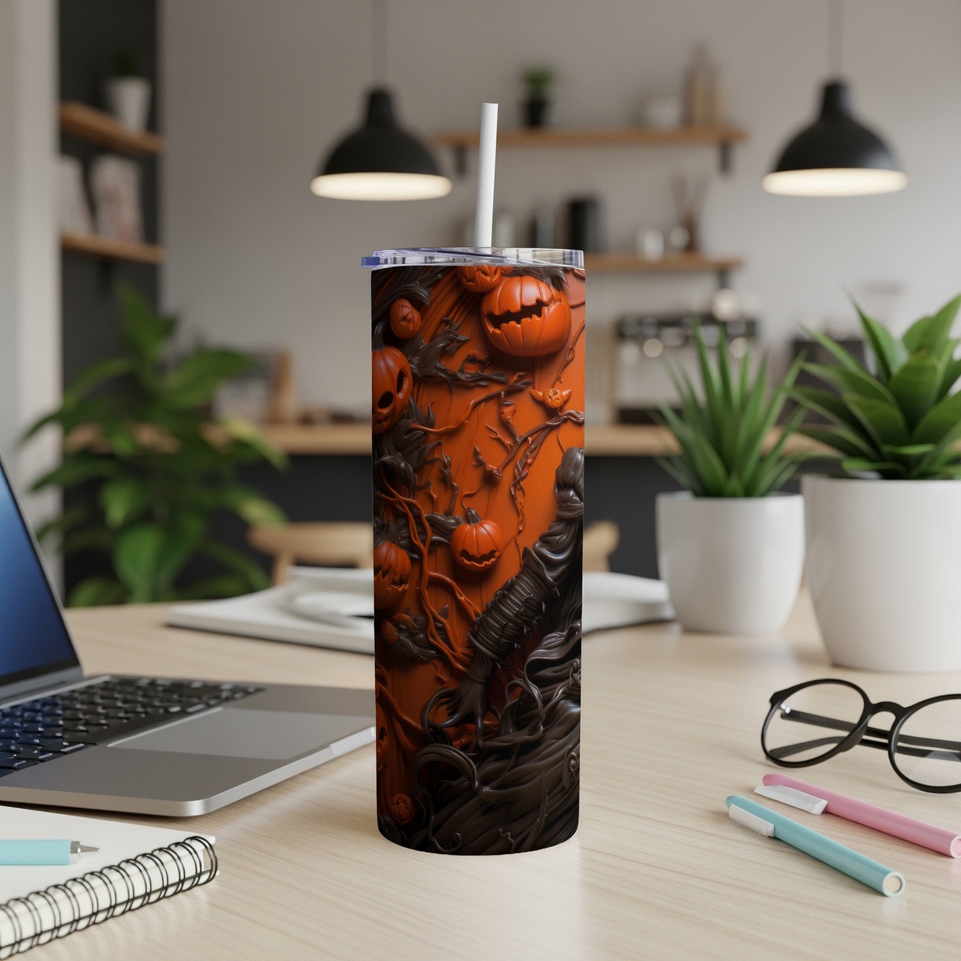Tumbler with orange background and carved Halloween pumpkins and dark, swirling designs.