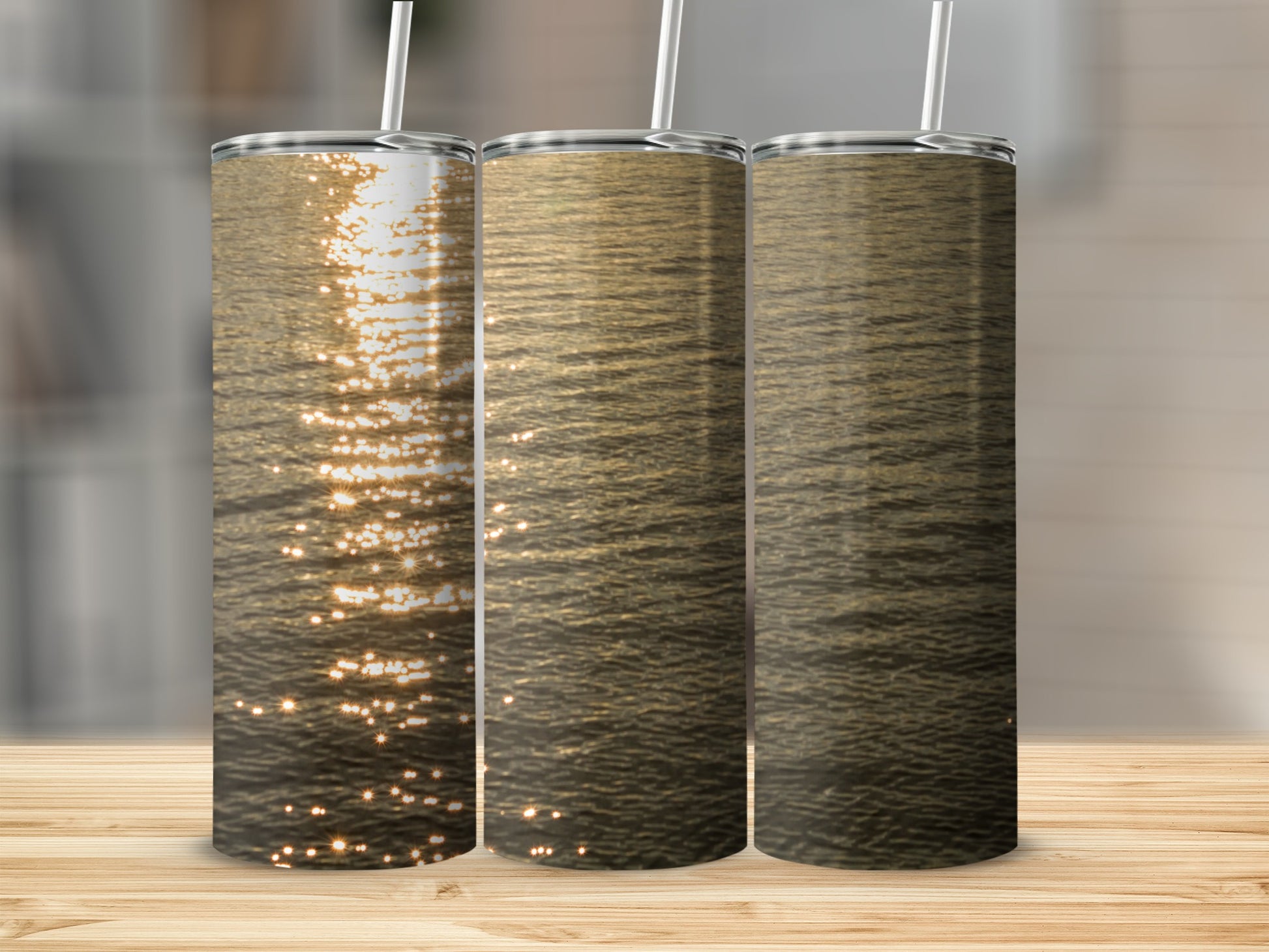 Three tumblers showing a serene sunset over rippling water.