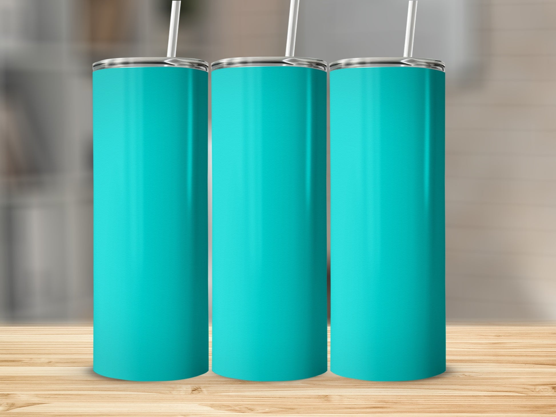 Three teal tumblers with straws on a wooden surface.