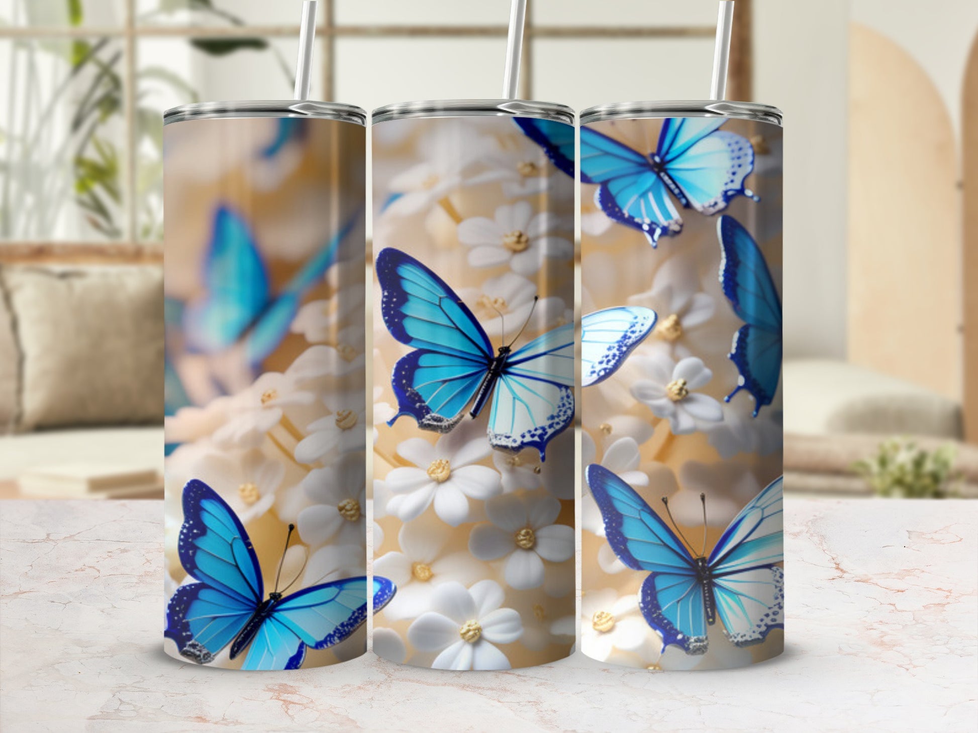 Three tumblers with blue butterflies and white flowers, displayed on a marbled surface.