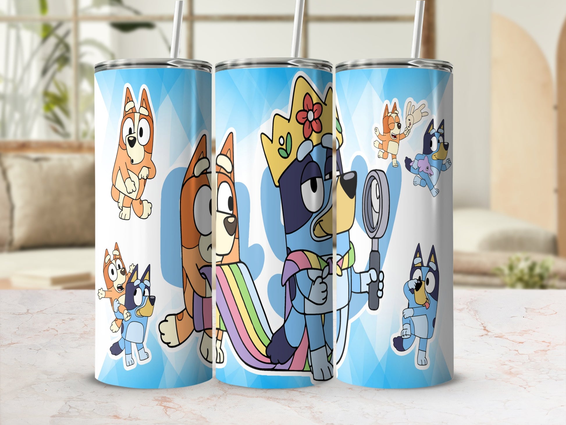 Three Bluey characters on tumblers, one with a crown and rainbow cape.