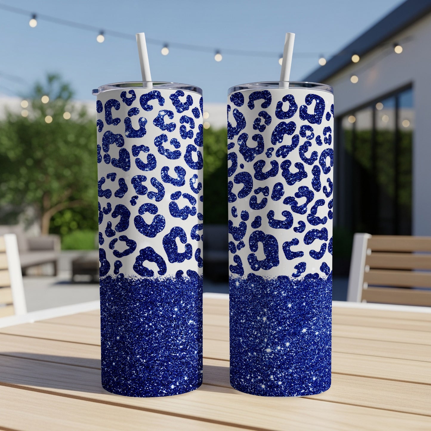 Two glittery blue leopard print tumblers with straws on a table.