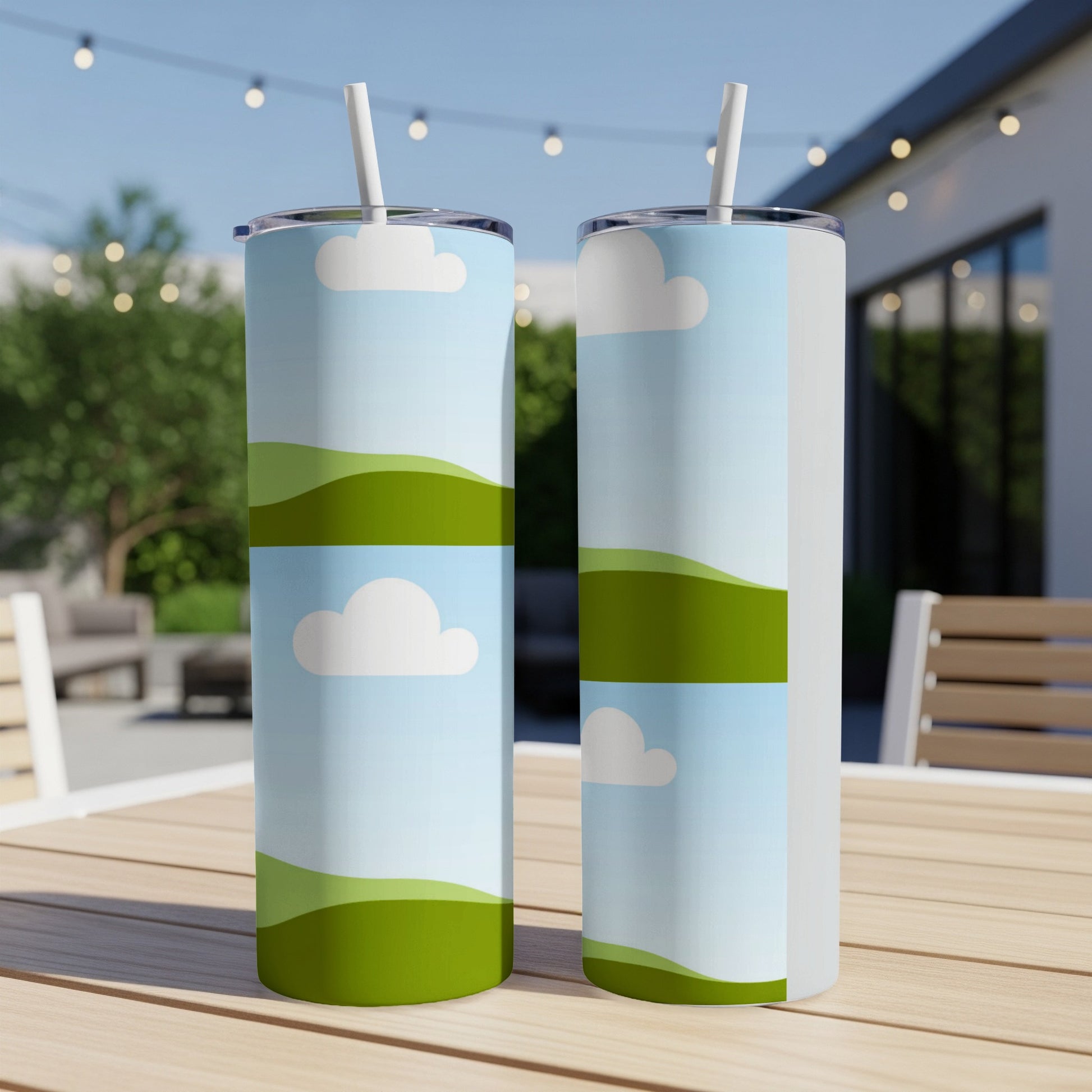 Two tumblers with a cartoon landscape design featuring green hills and clouds.