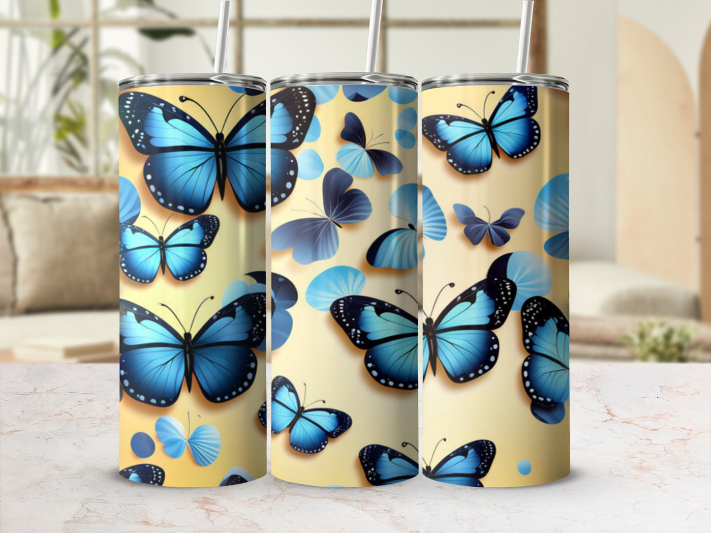 Three tumblers decorated with blue butterflies on a pale yellow background.