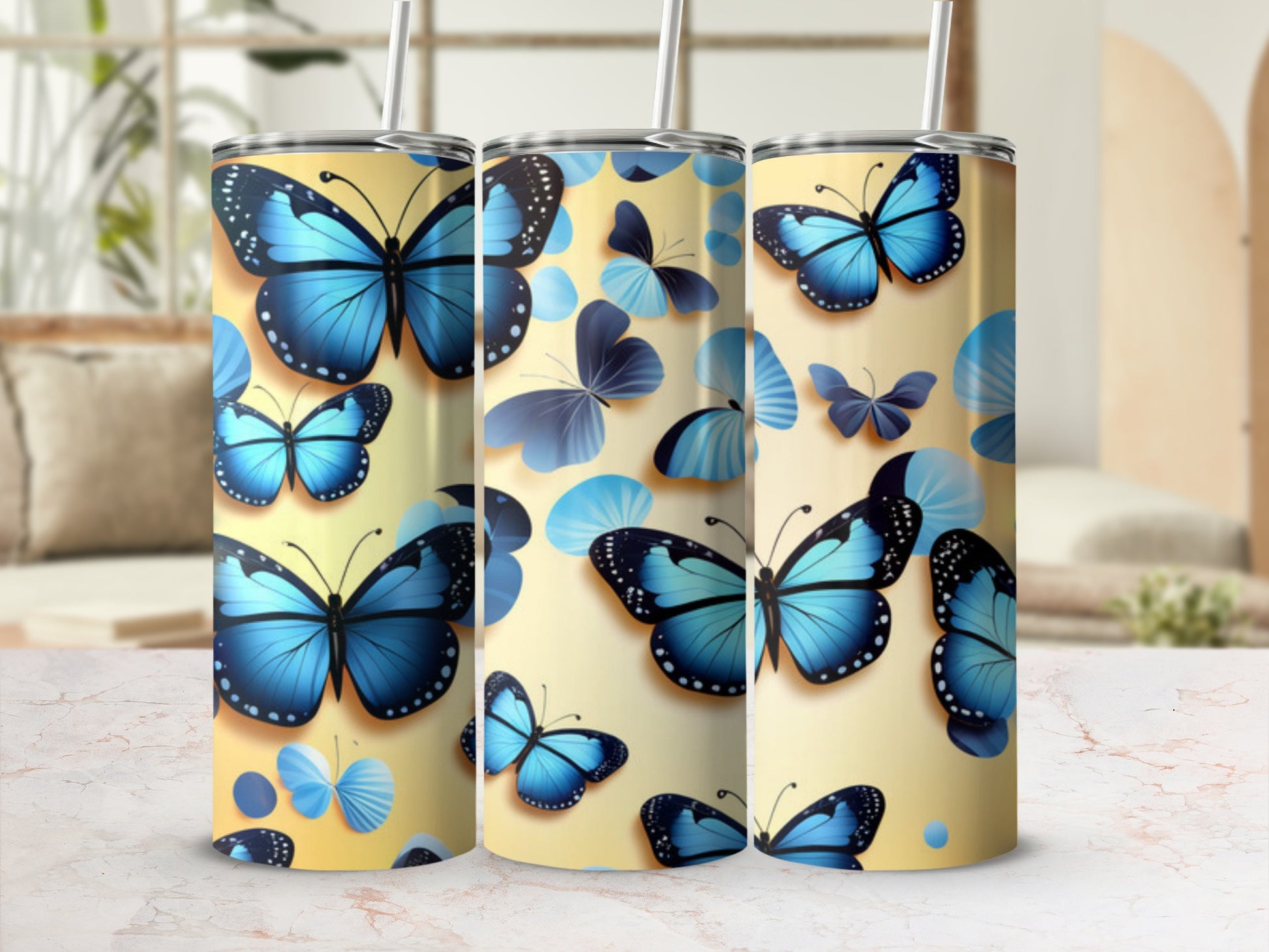 Three tumblers decorated with blue butterflies on a pale yellow background.