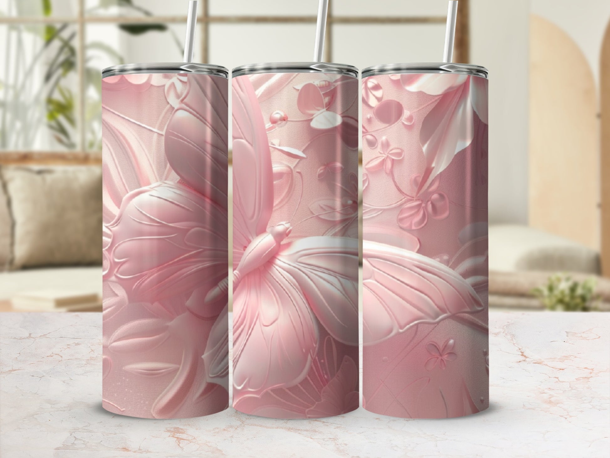 Pink butterfly and floral design on three tumblers with straws.