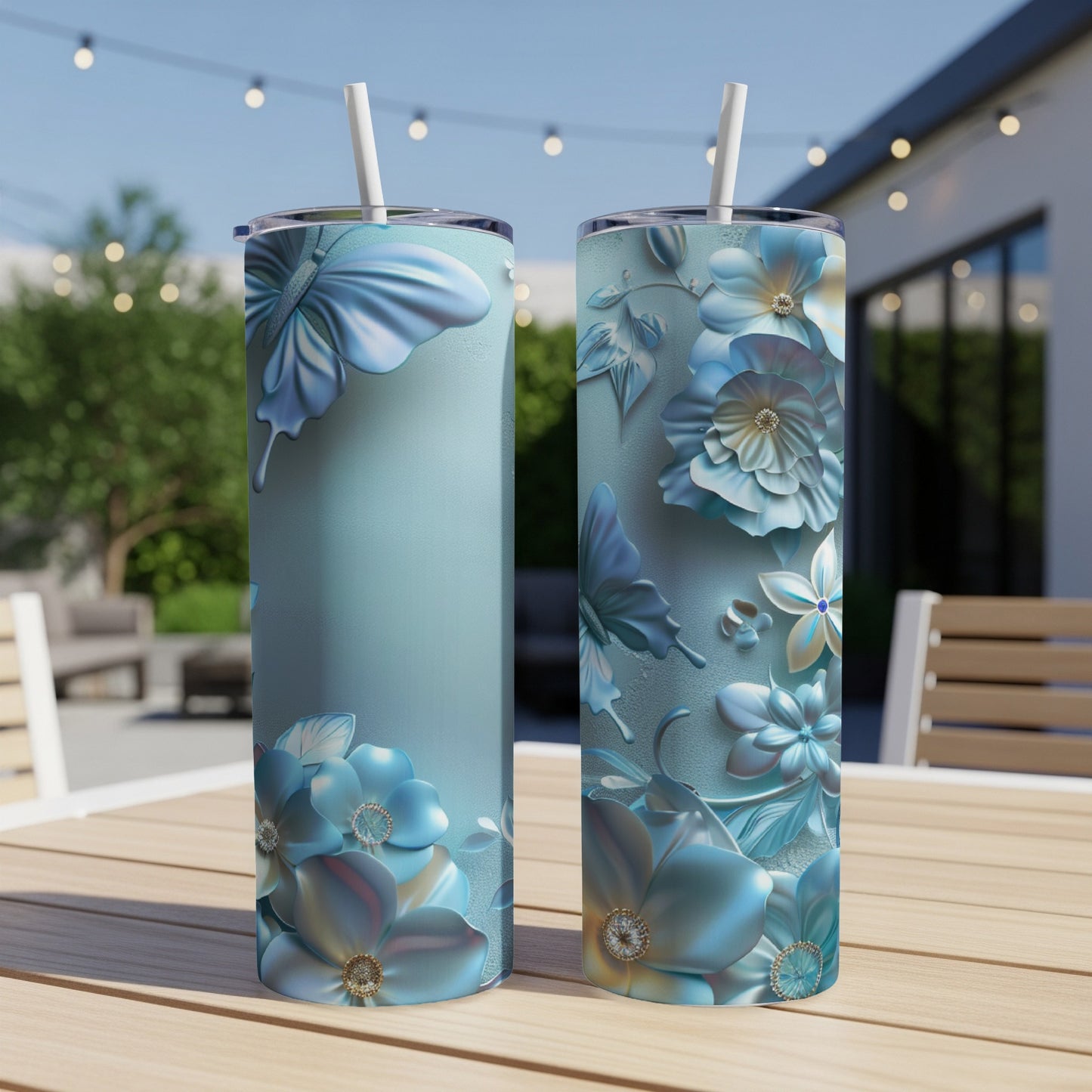 Two tall tumblers with blue floral and butterfly designs on a table.