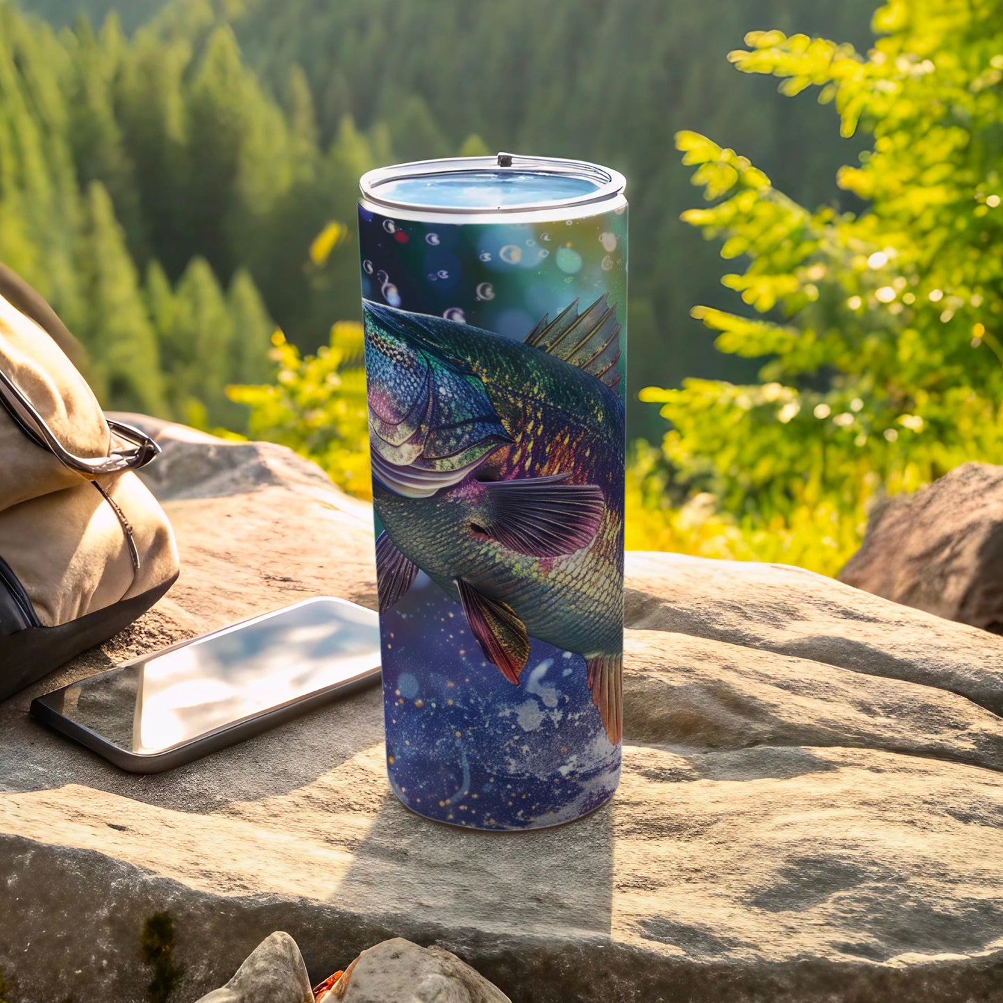 Fish artwork on a blue speckled tumbler with outdoor background.