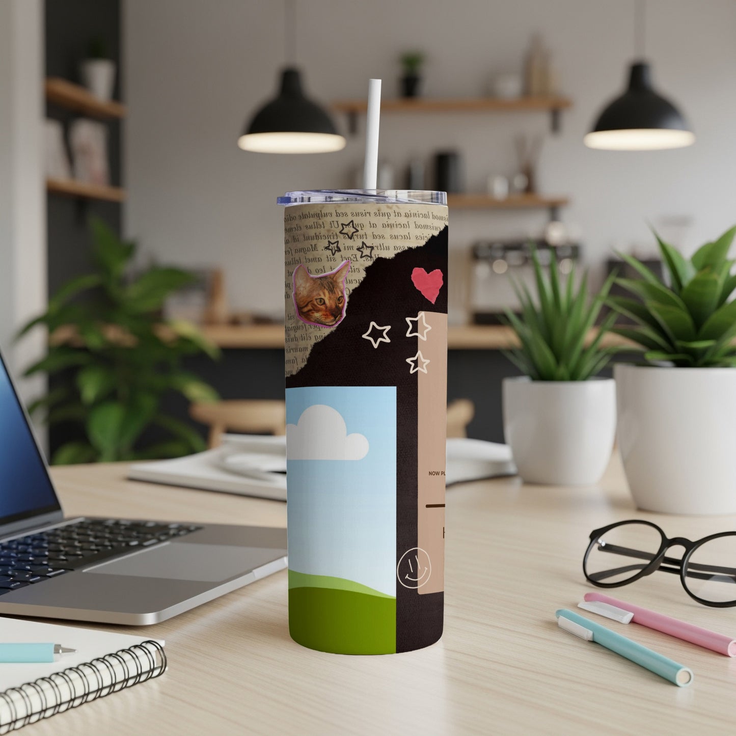 Collage tumbler with cat, stars, heart, and landscape design.