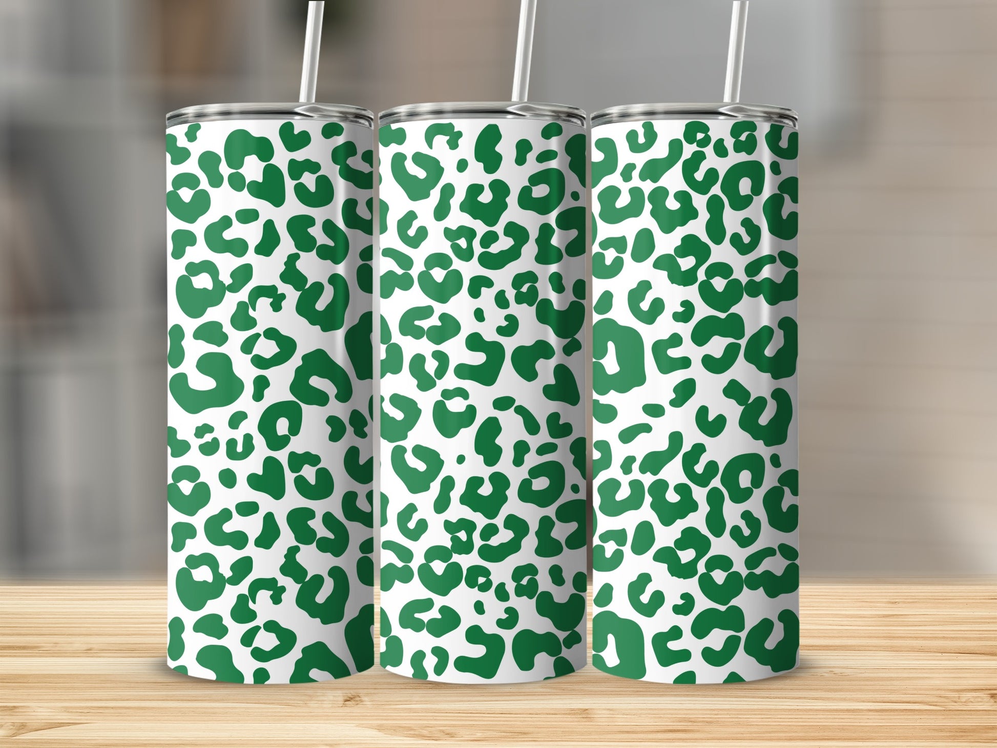 Three tumblers with white and green leopard print pattern, each with a straw.