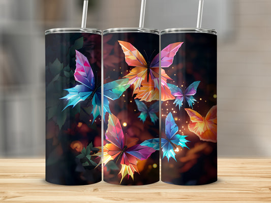 Three tumblers with geometric butterfly designs and straws on a wooden surface.