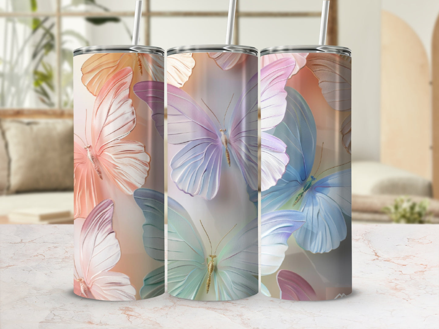Three tumblers with iridescent butterfly designs and straws.