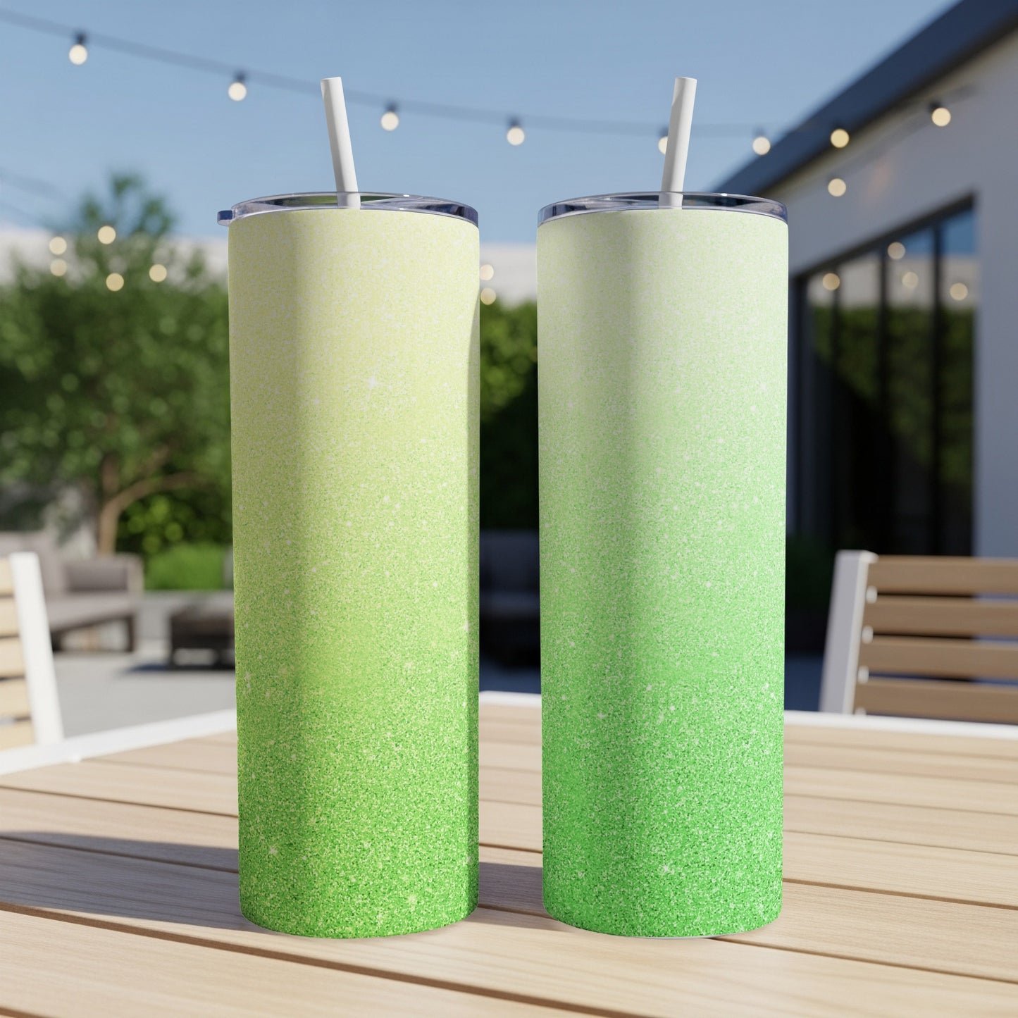 Two glitter tumblers with a green to yellow gradient, on a wooden table outdoors.