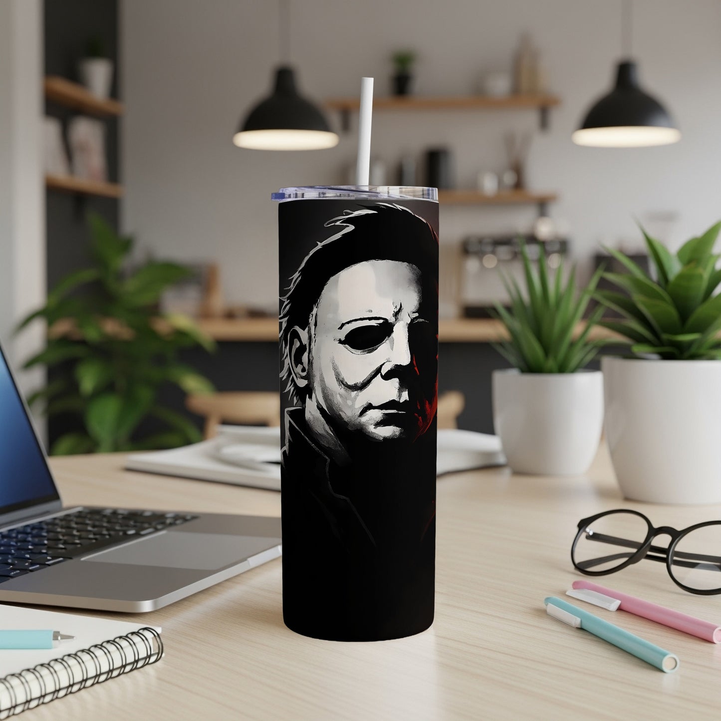 Michael Myers tumbler with white straw on a wooden desk.