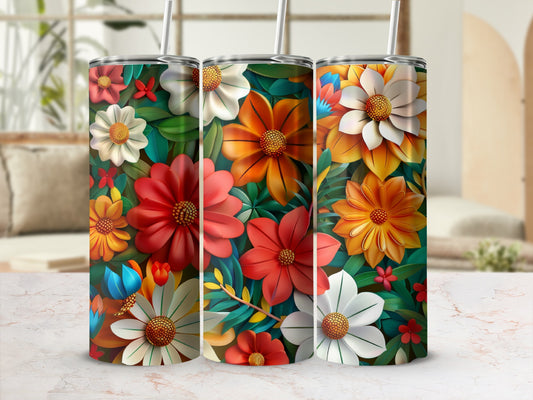 Three tumblers with colorful floral designs and straws on a marble surface.