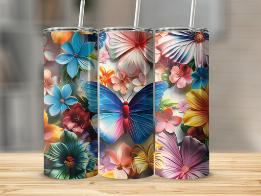 Three tumblers with colorful floral and butterfly designs on a wooden surface.
