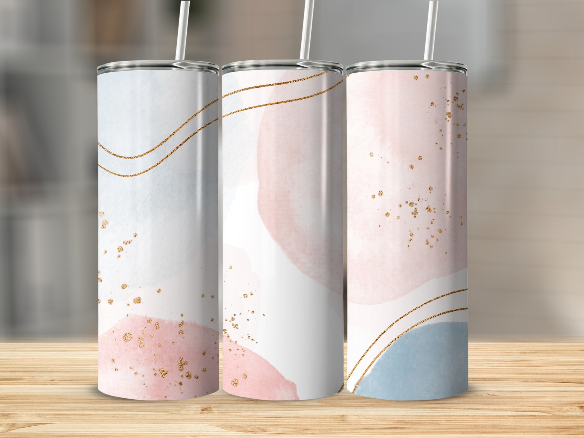 Three tumblers with watercolor abstract designs and gold accents.
