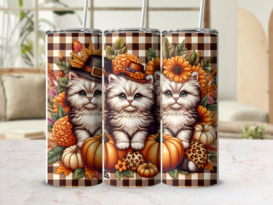 Three tumblers with fluffy kittens, pumpkins, and autumn leaves on plaid background.