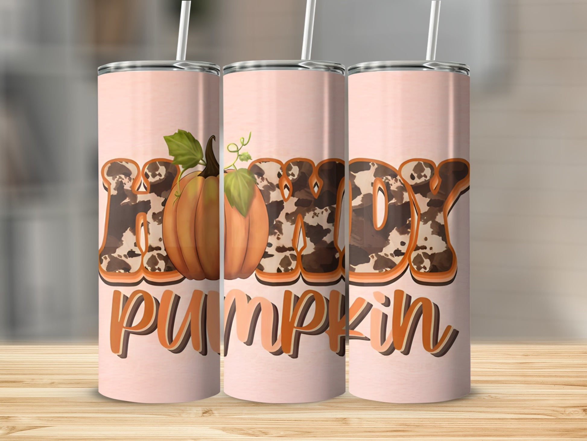 Pink tumbler with "Happy Pumpkin" text and cow print detail.