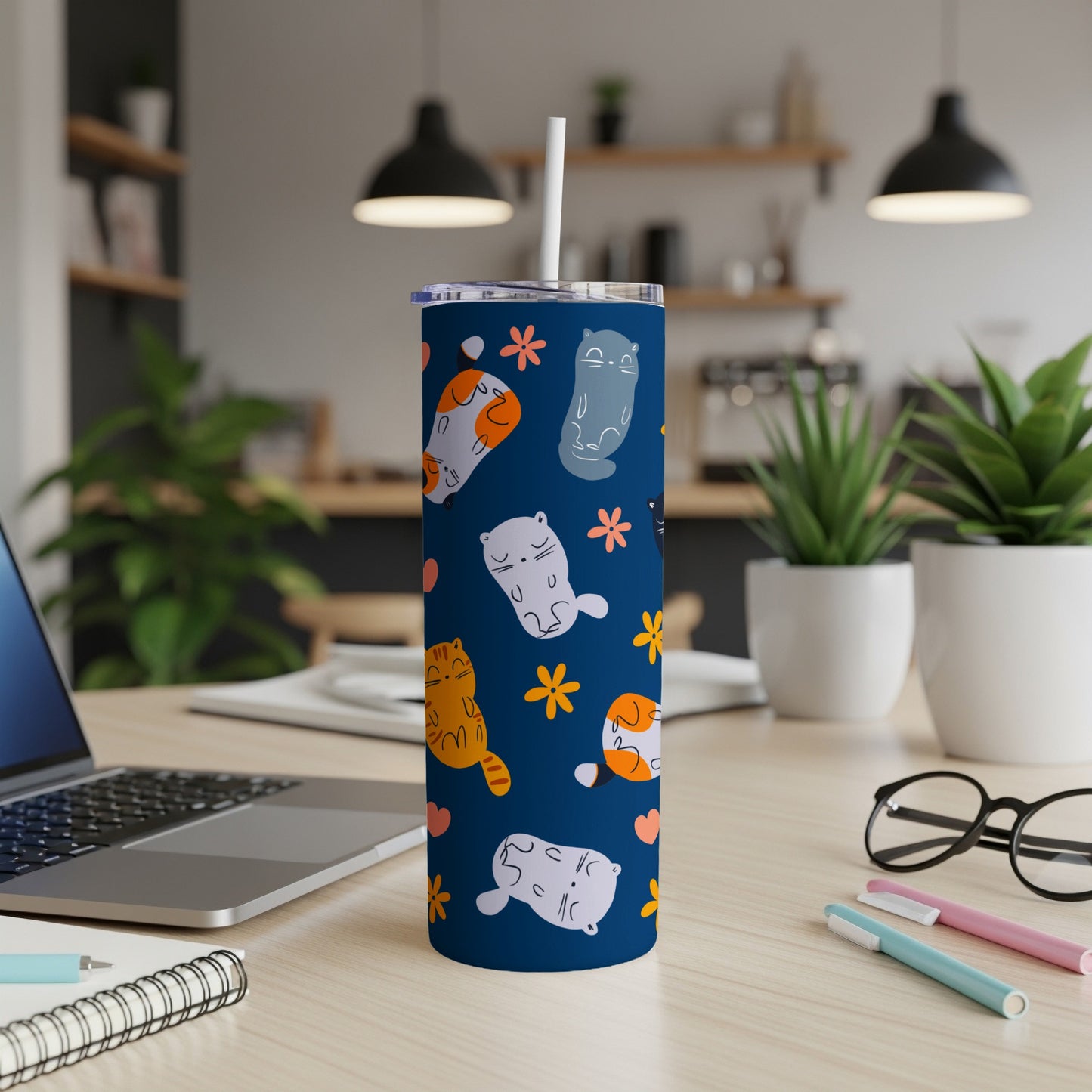 Dark blue tumbler with cartoon cats and flowers pattern.
