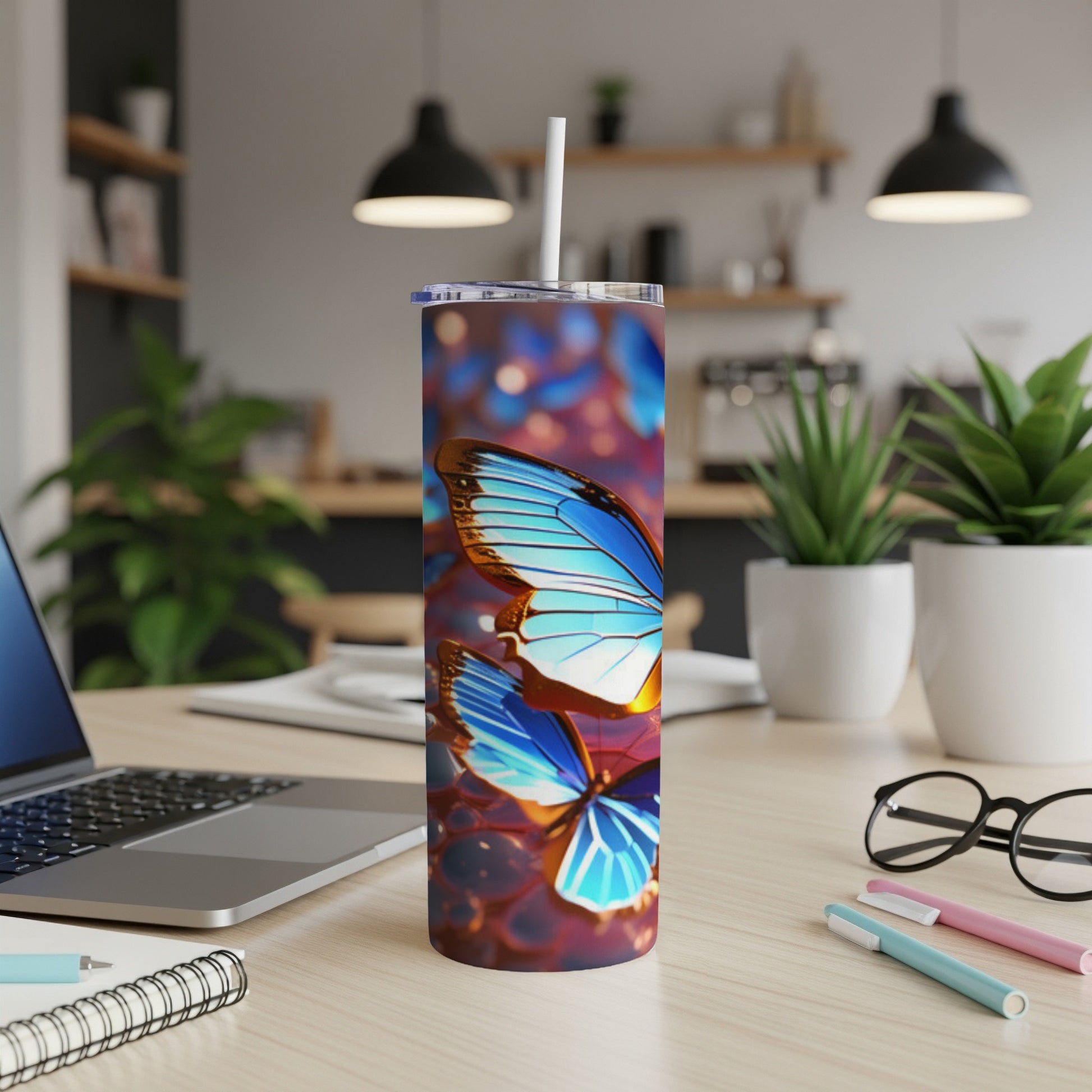 Two iridescent blue butterflies on a patterned blue tumbler with a straw.