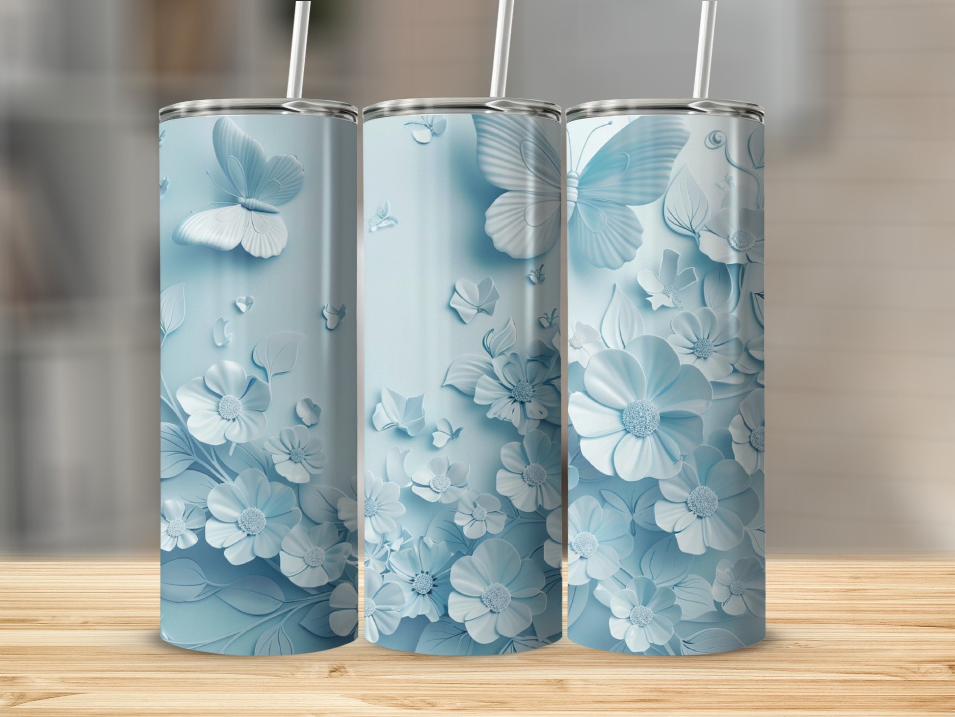 Three light blue tumblers with raised floral and butterfly designs.