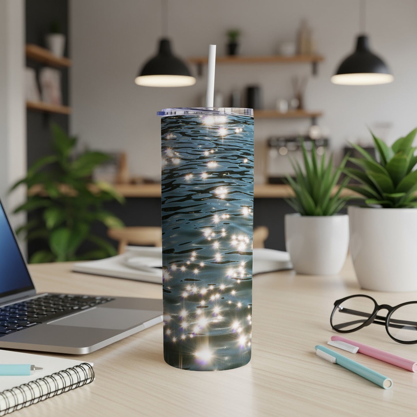 Sparkling water reflected light on a skinny tumbler, placed on a desk.