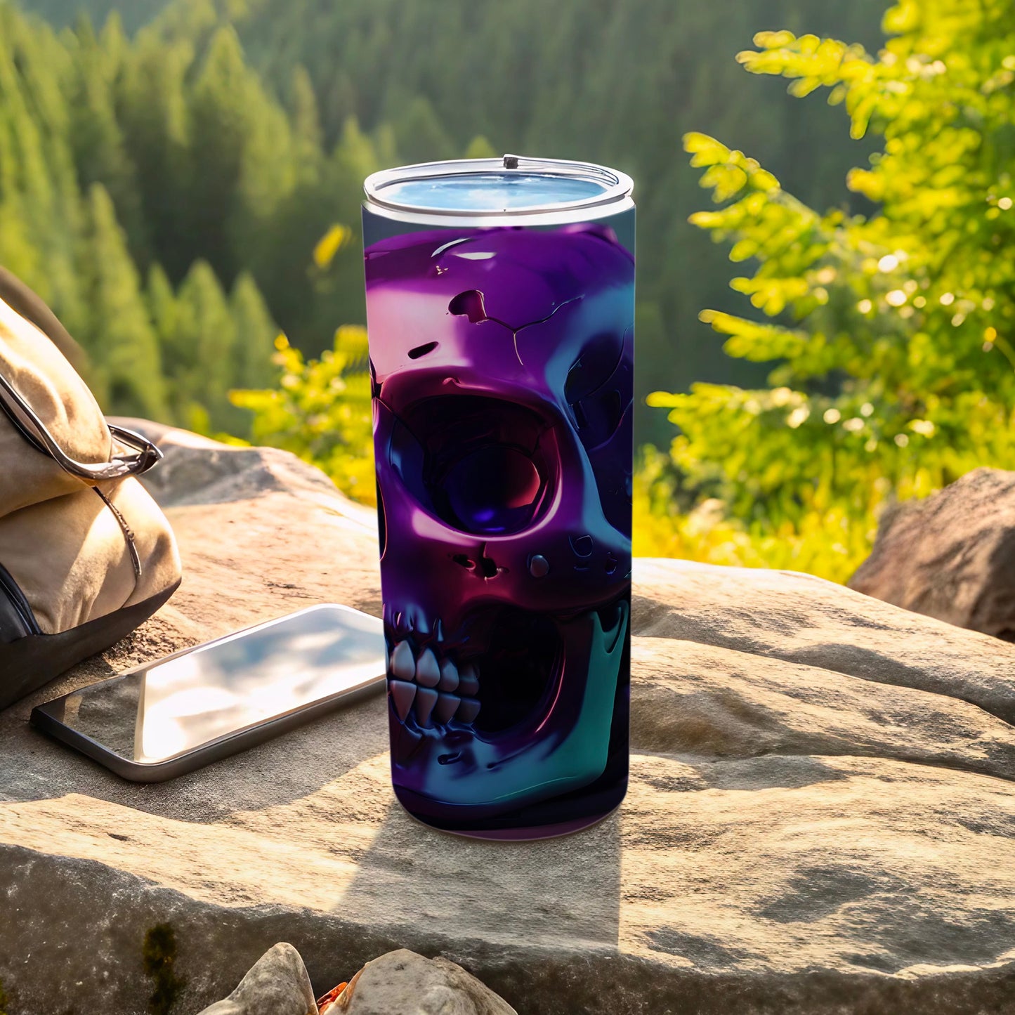 Tumbler with a purple and blue skull design sits on a rock outdoors.