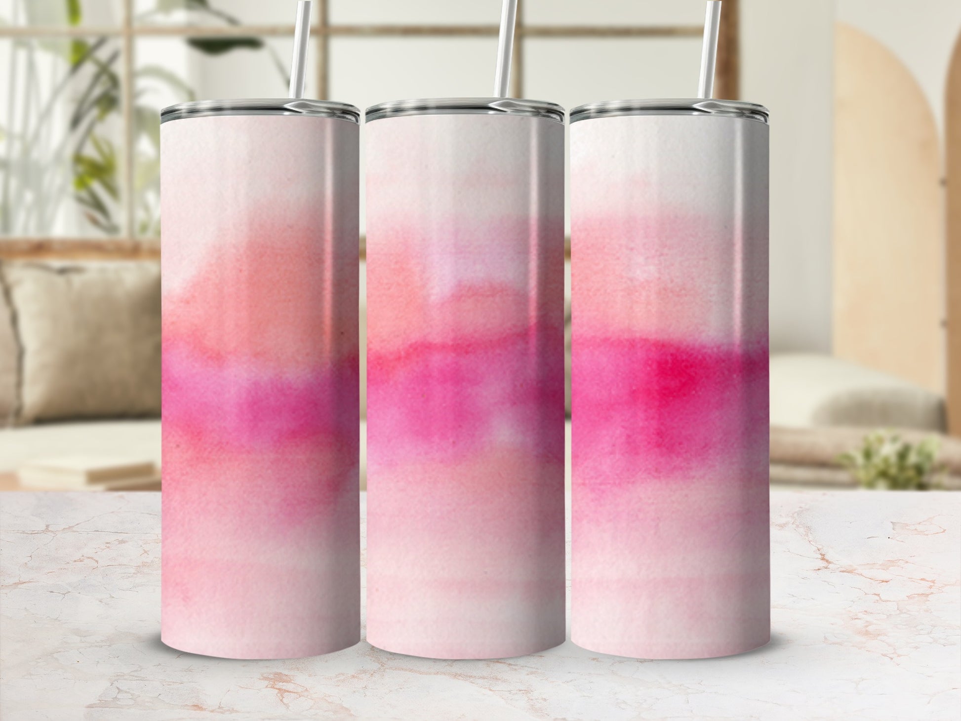 Three pink and white watercolor pattern tumblers with straws.