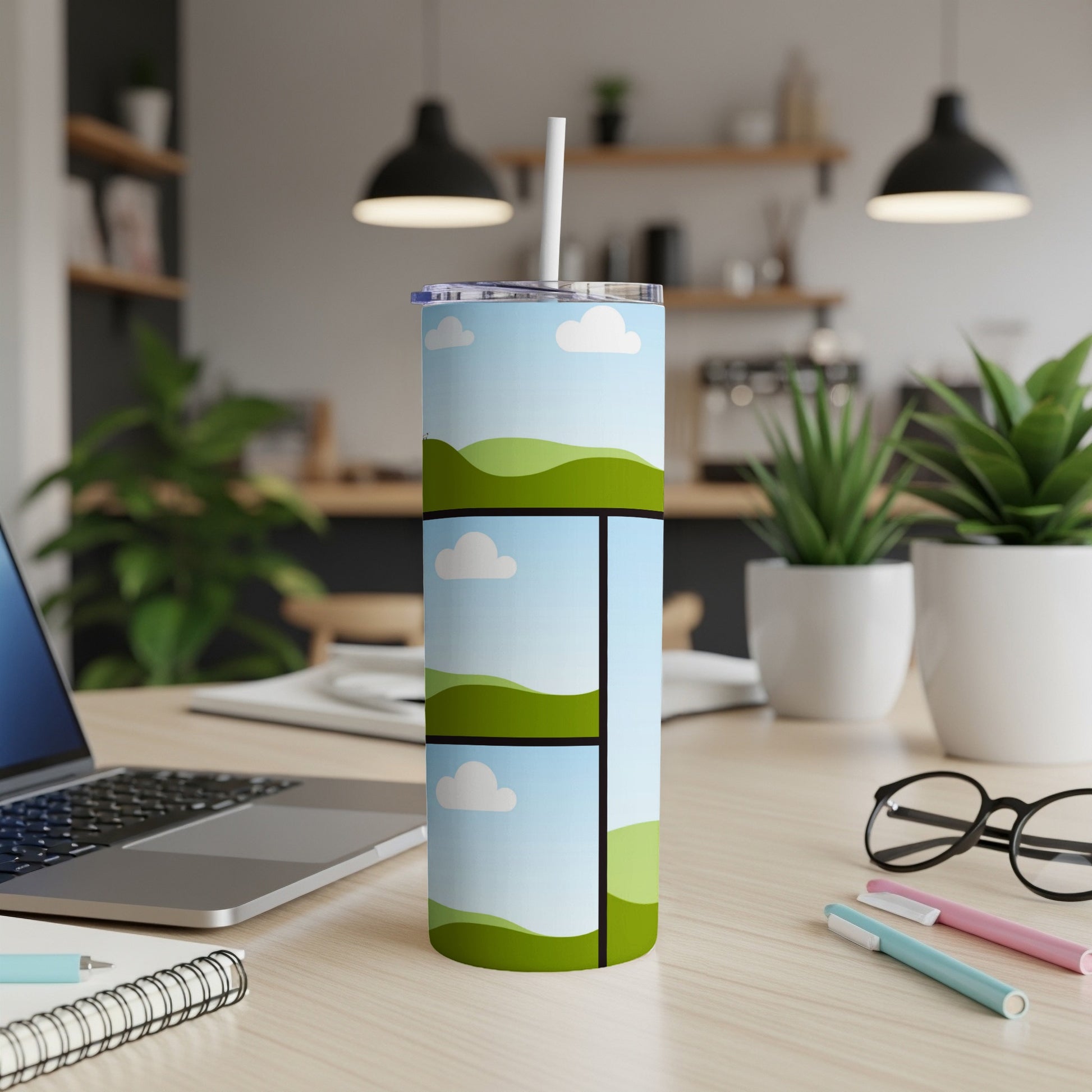 Tumbler with cartoon sky and green hills design and a white straw.