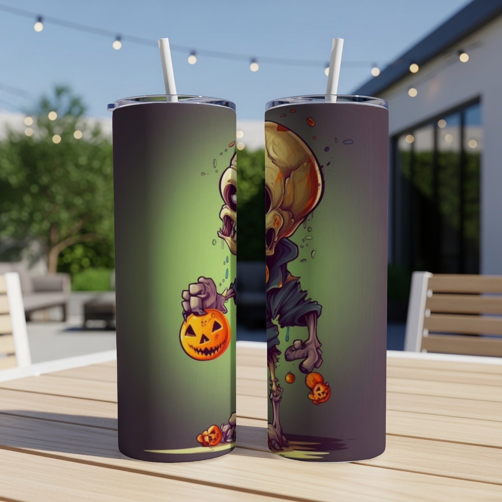 Two tumblers with cartoon skeleton holding pumpkins on a table outdoors