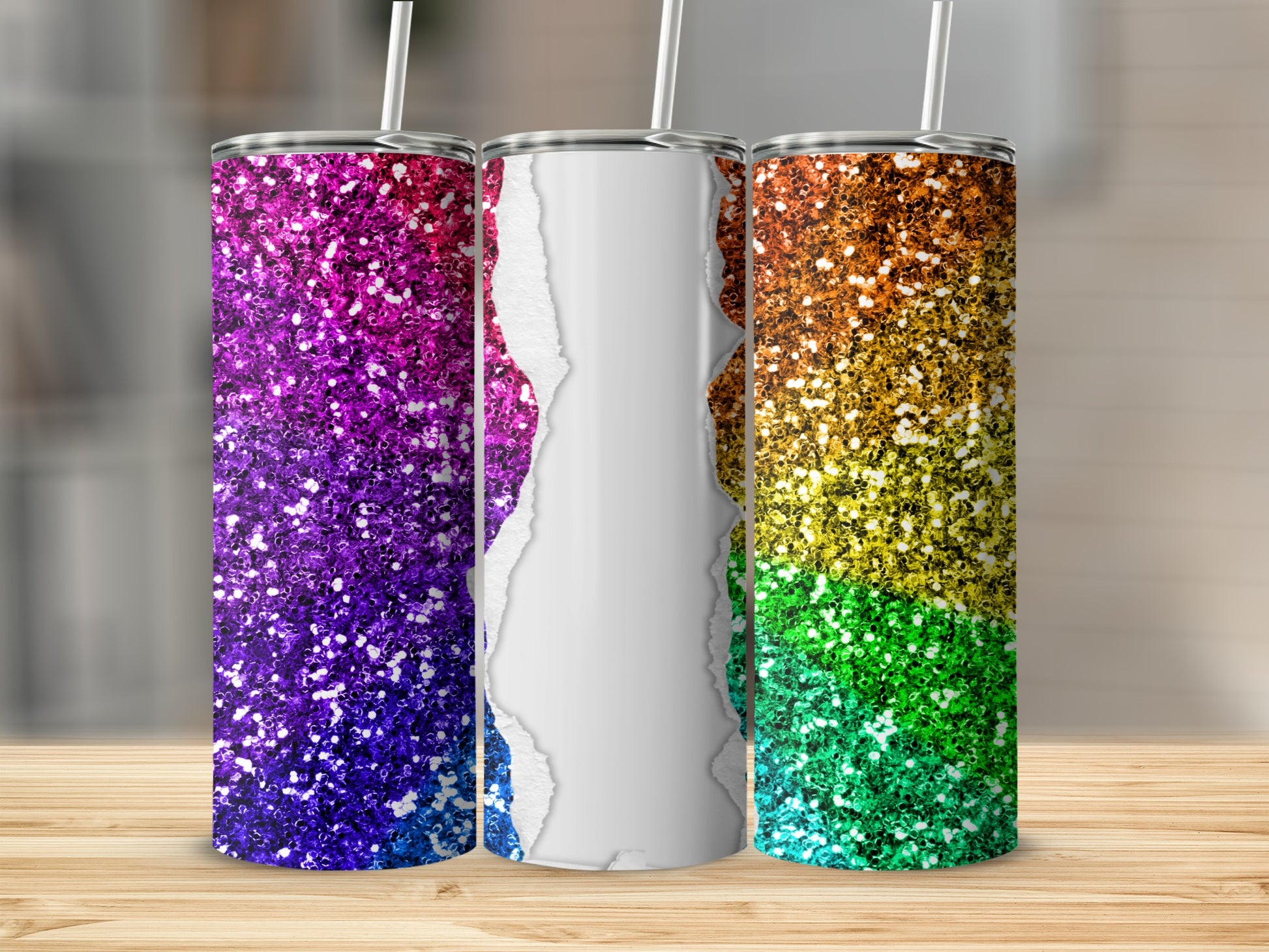 Three glitter-covered tumblers with rainbow and purple designs on a wooden surface.