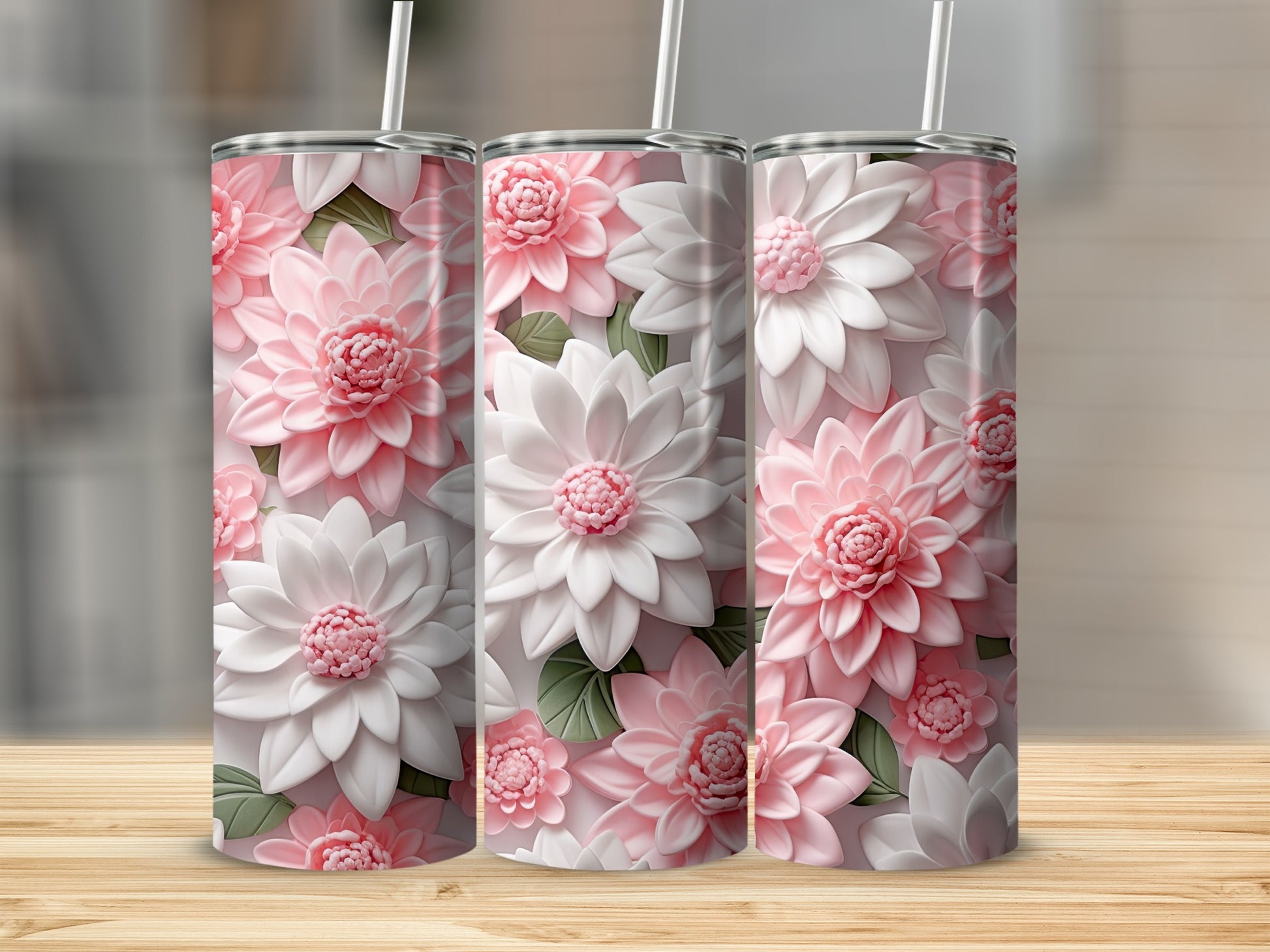 Three pink and white floral patterned tumblers with straws.