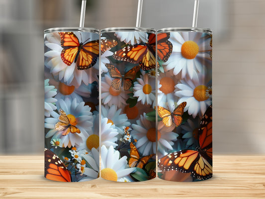 Butterflies and daisies decorate three tumblers on a wooden surface.