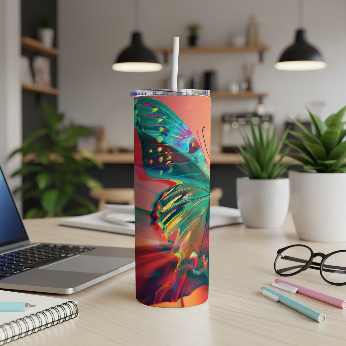 Abstract butterfly design on a tall, insulated tumbler with a straw.