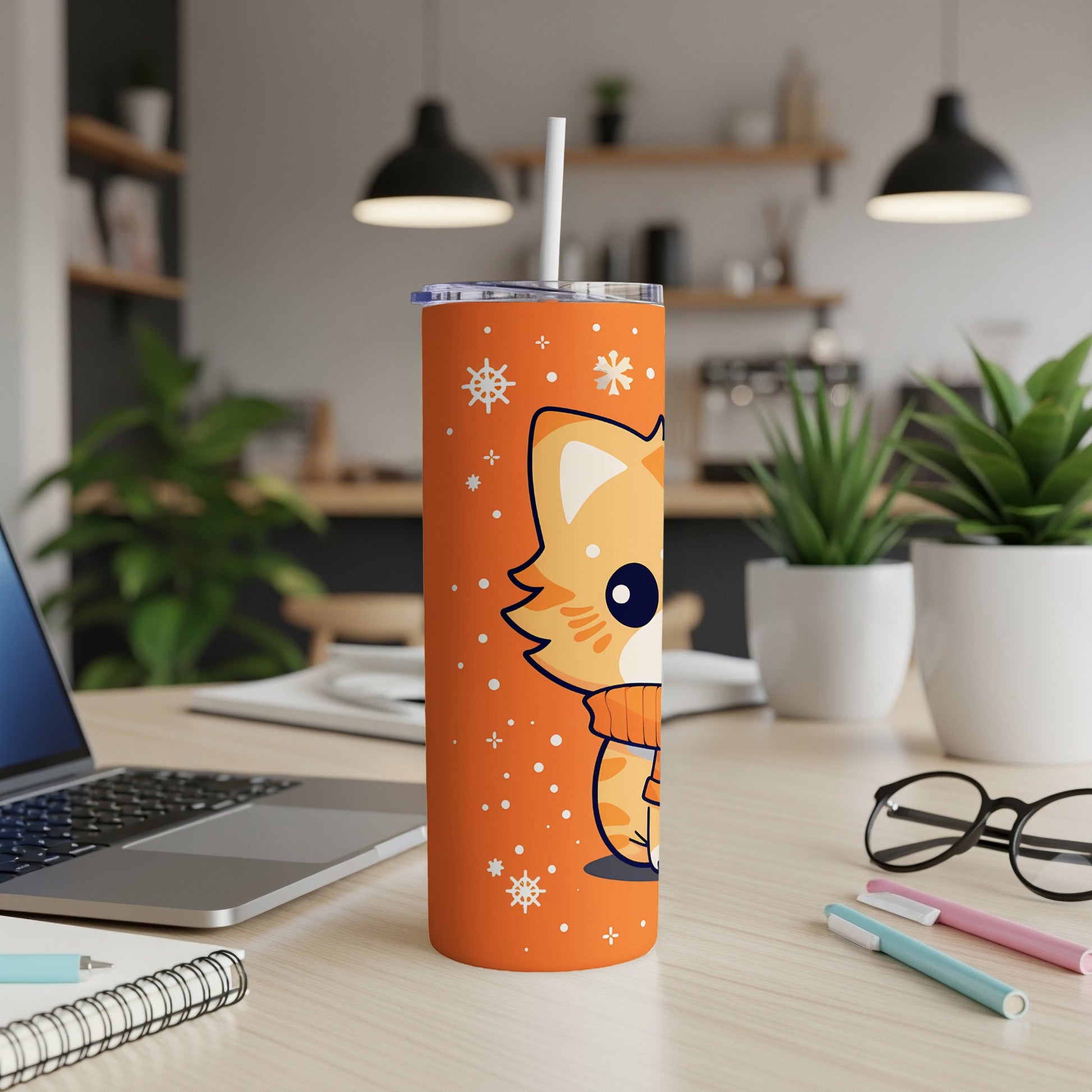 Orange tumbler with a cartoon cat wearing a sweater, snowflakes, and a straw.