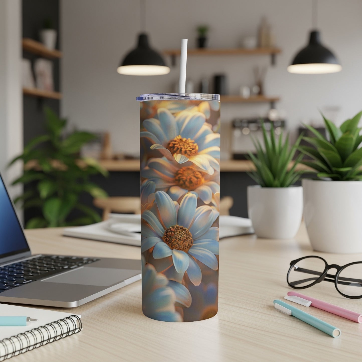 Blue and yellow flowers wrap around a skinny tumbler with a straw.