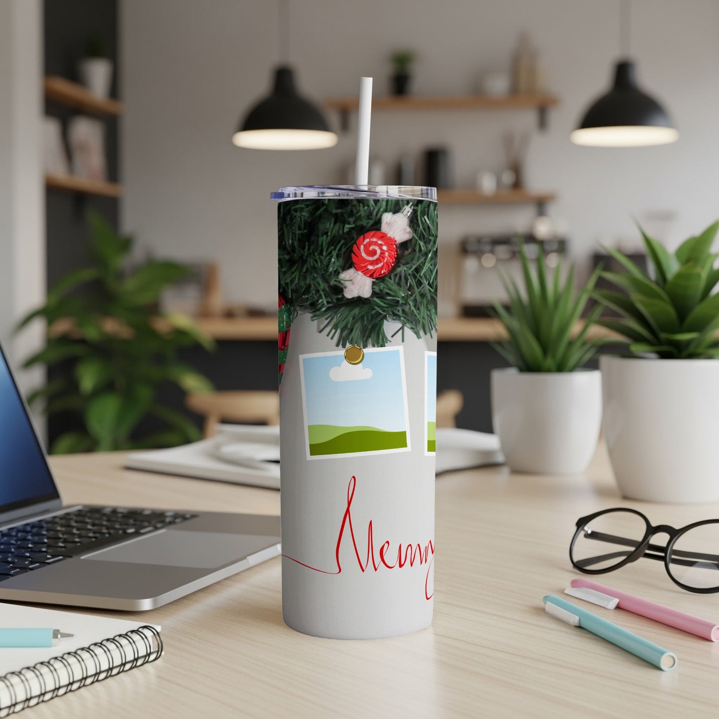 Tumbler with Christmas garland, candy, and "Merry" script on a desk.