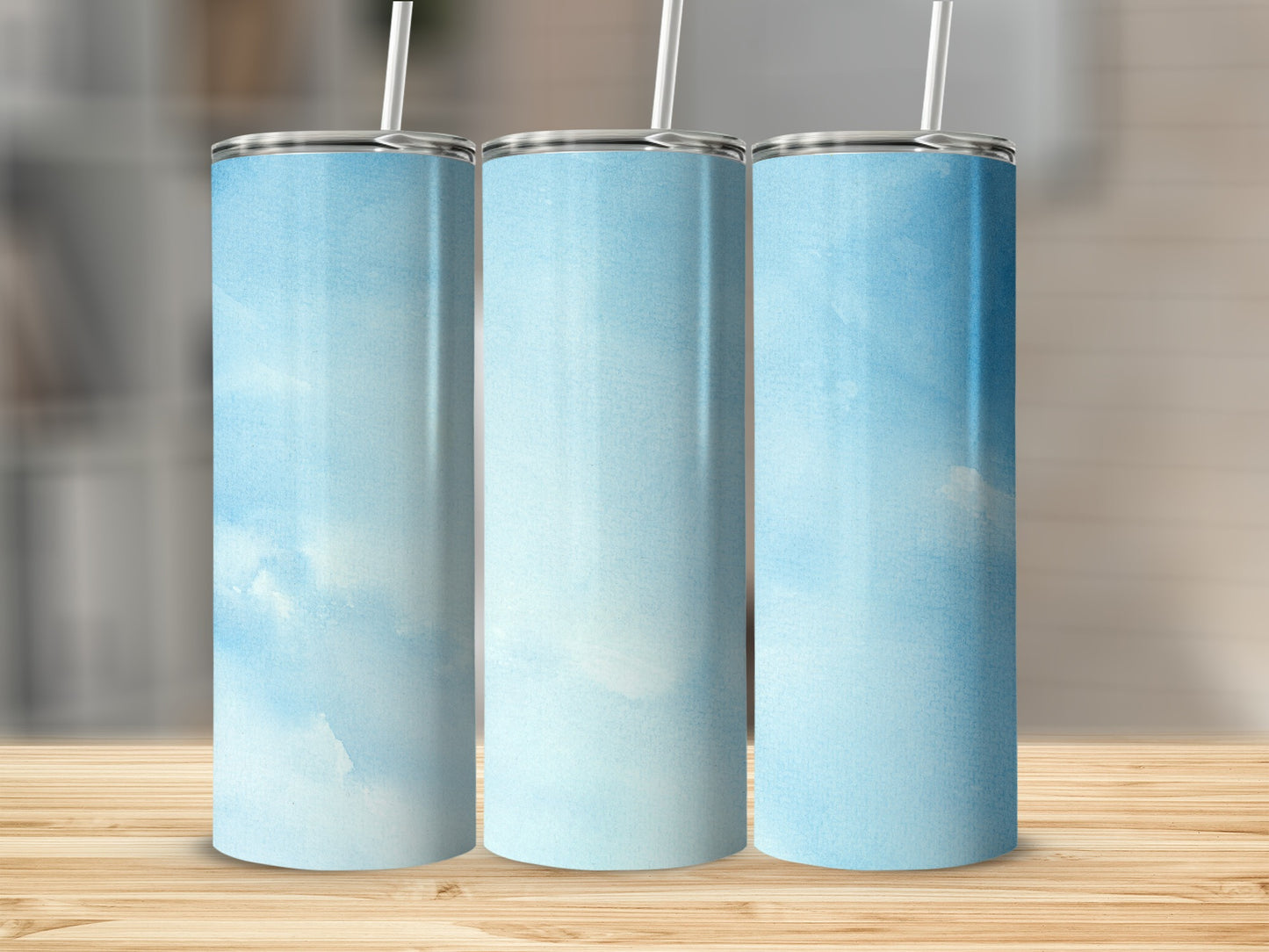 Three tumblers with a light blue watercolor sky pattern and straws.
