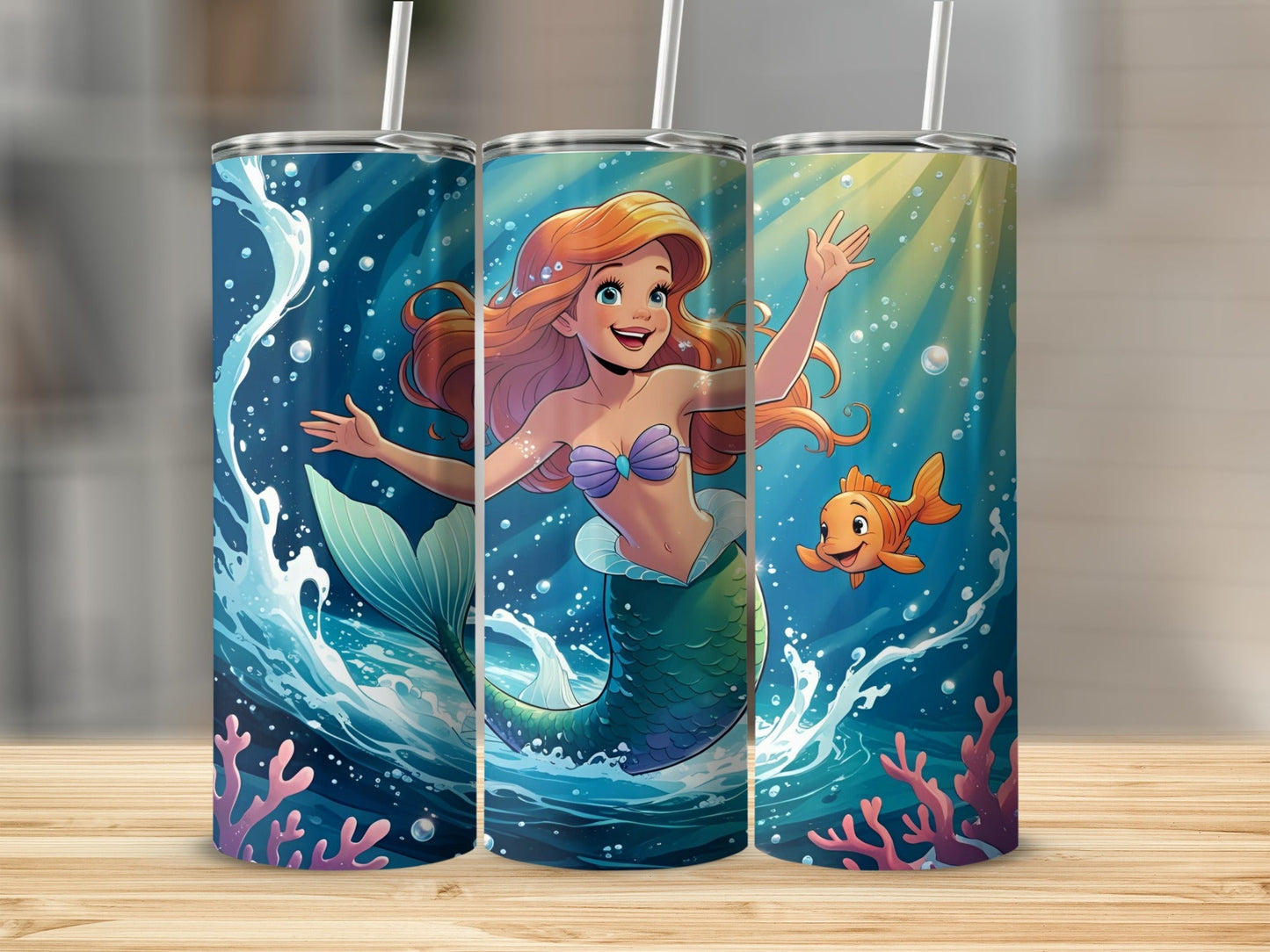 Ariel the mermaid with a fish and coral, on a blue and green tumbler.