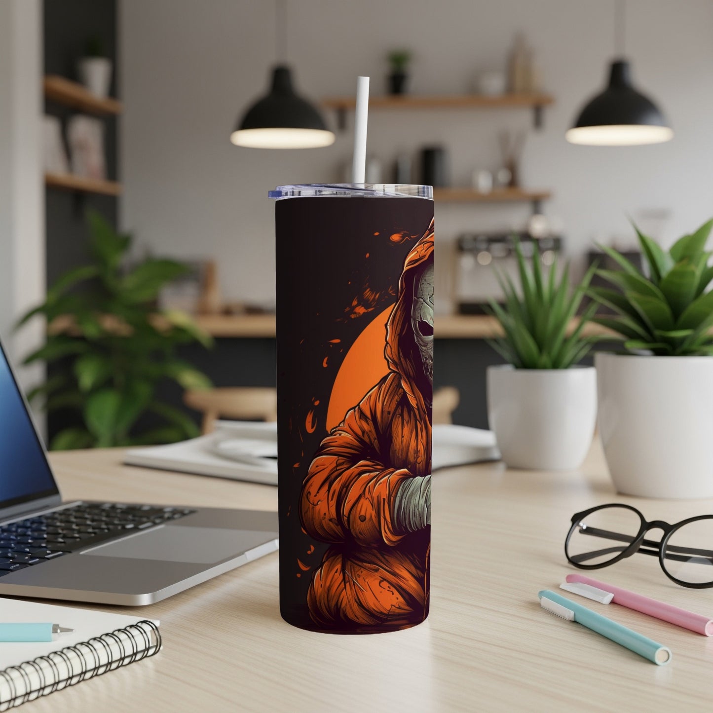 Tumbler with Grim Reaper graphic, white straw, on a desk.