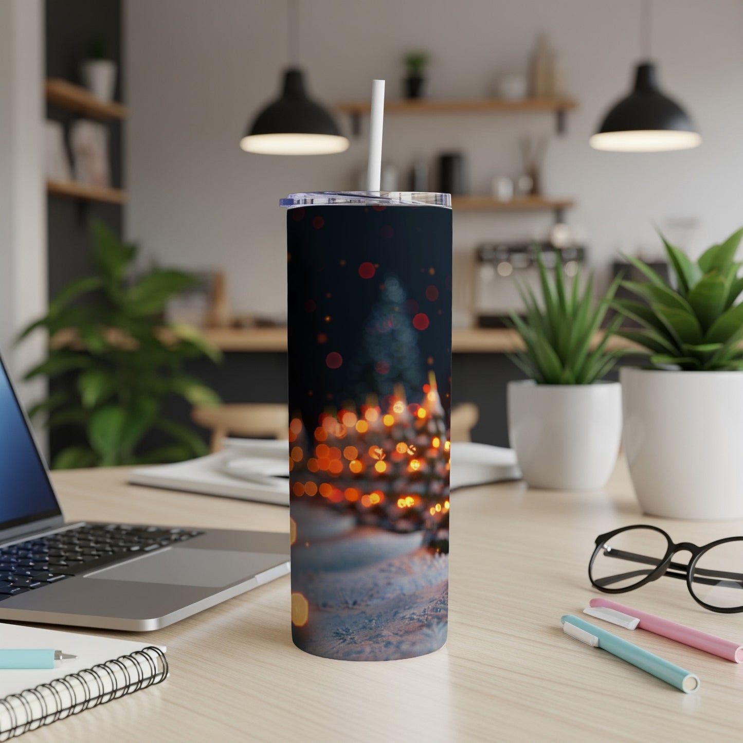 Tumbler with blurry Christmas lights and snow overlay, on a desk.