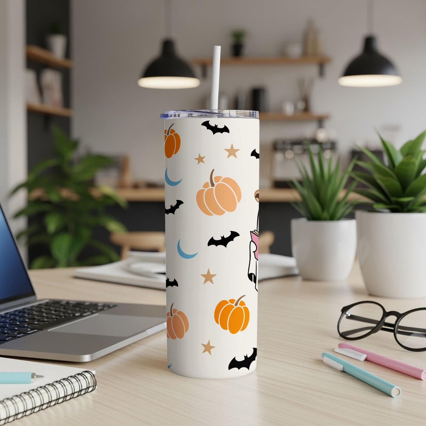 White tumbler with Halloween pattern of pumpkins, bats, moons, and stars.