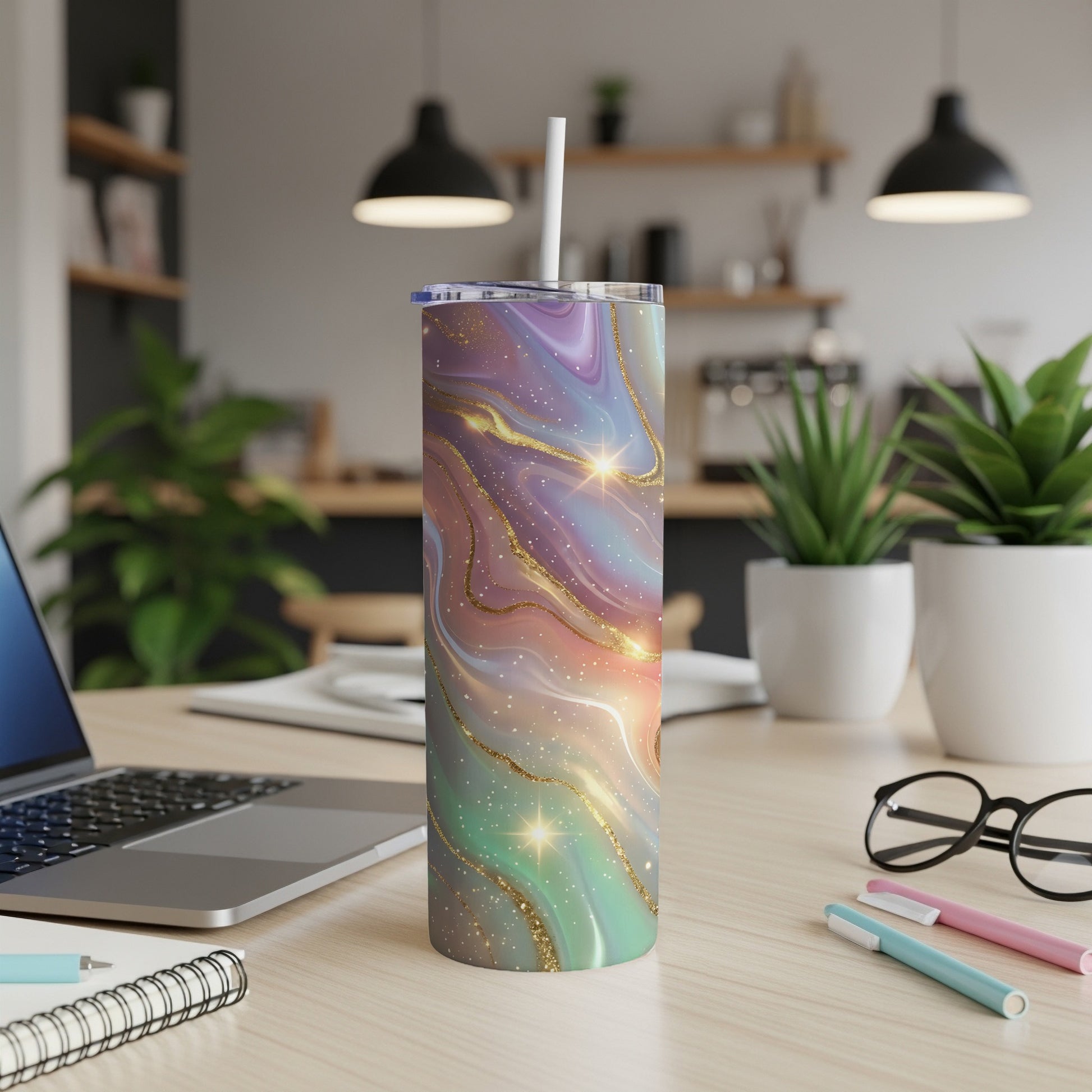 Marble swirl skinny tumbler with straw on a desk.