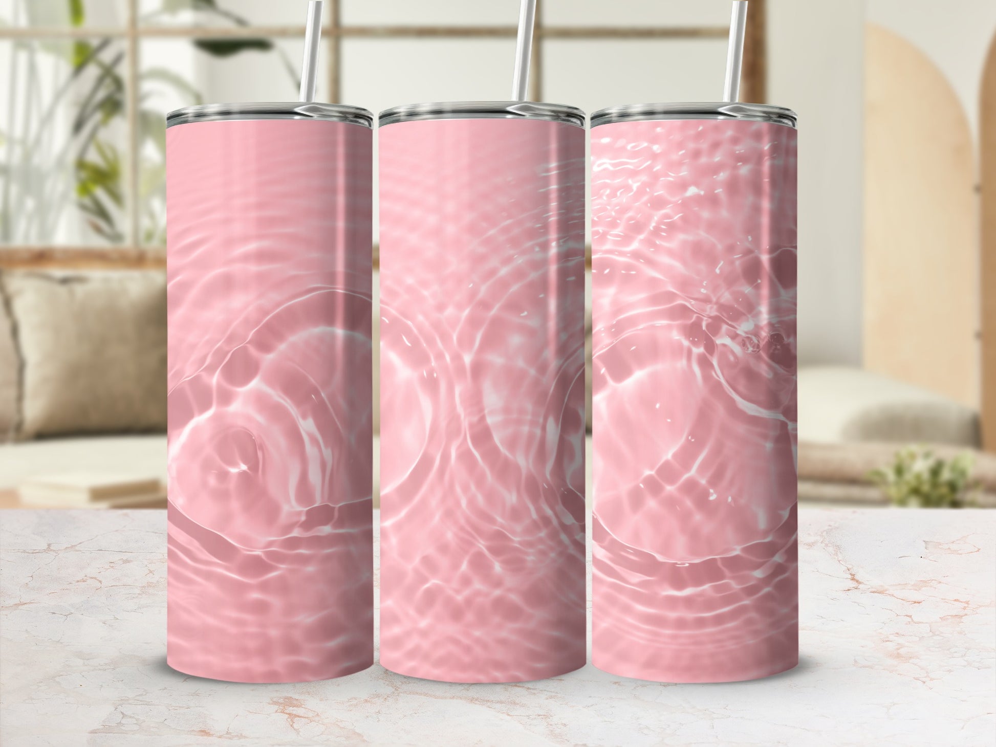 Three pink tumblers with water ripple pattern on a marbled surface.