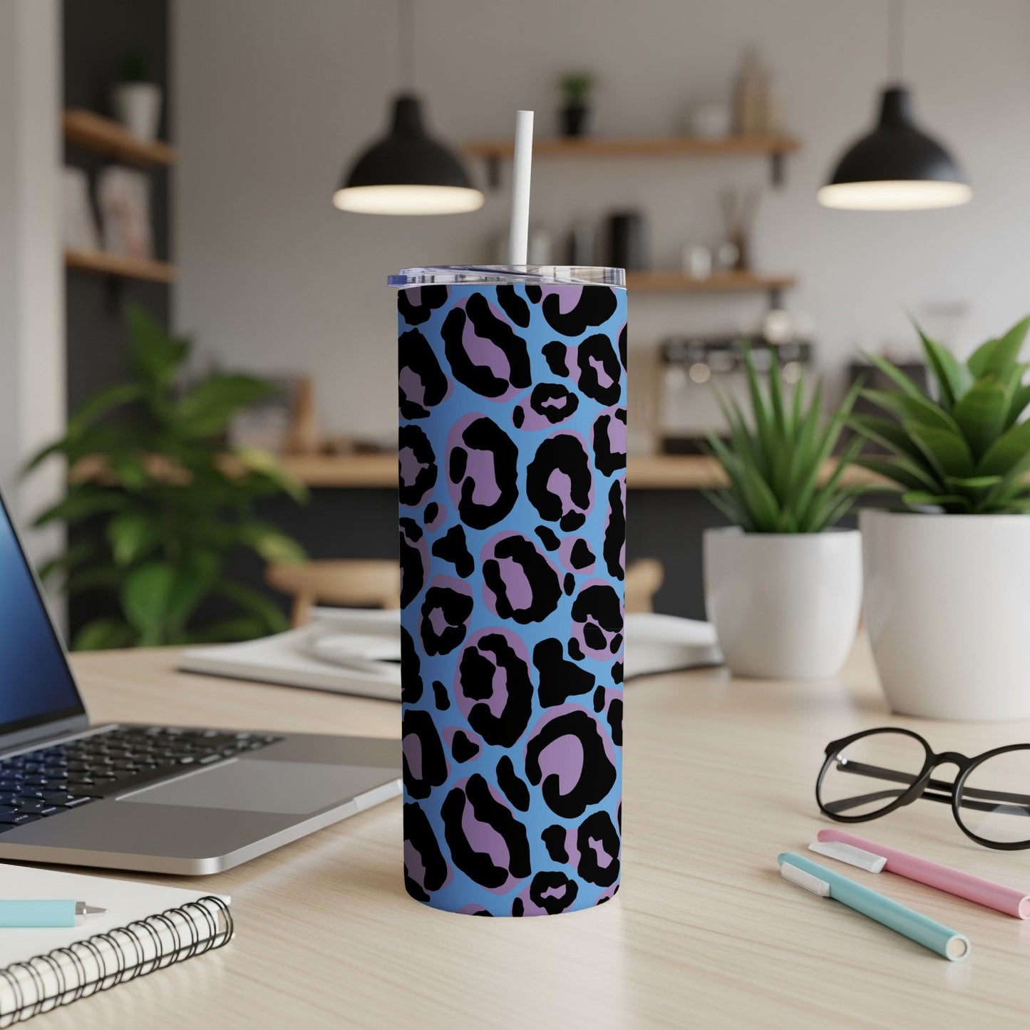 Blue tumbler with black and purple leopard print, featuring a white straw.