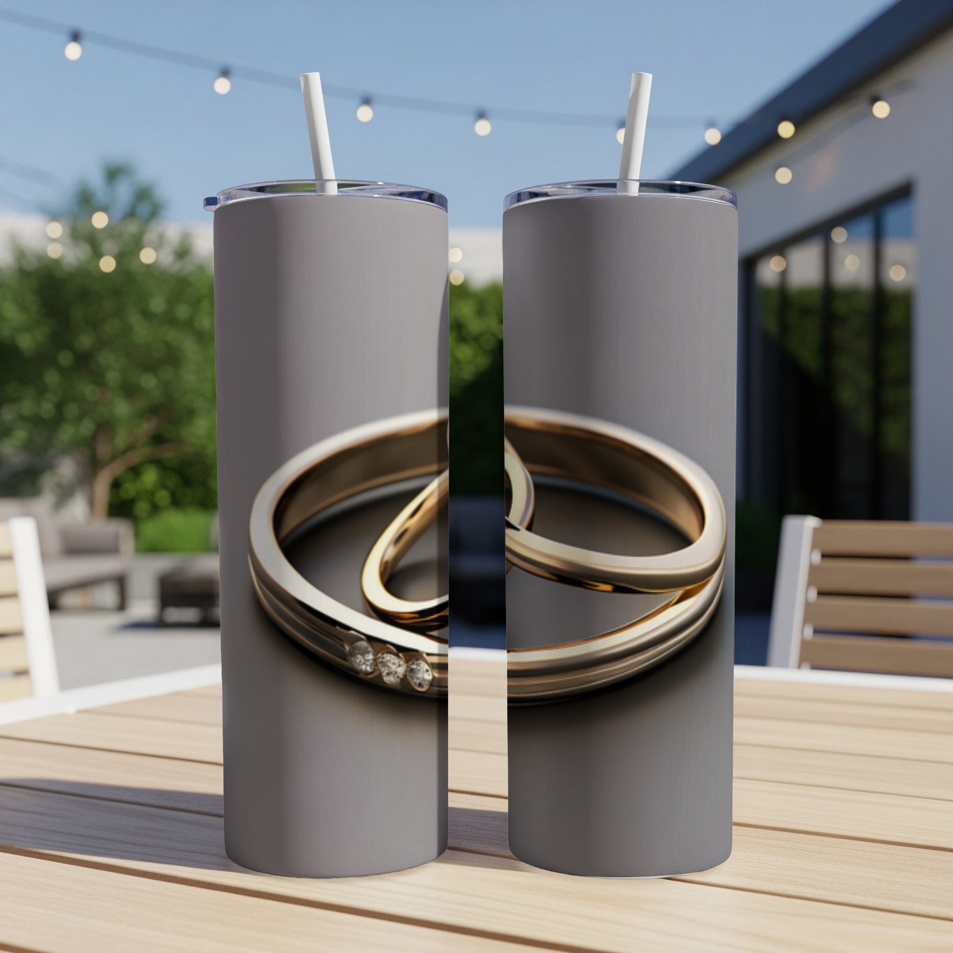 Two silver rings with three small diamonds on a grey tumbler.