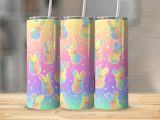 Three tumblers with pastel Easter bunny design on a wooden surface.