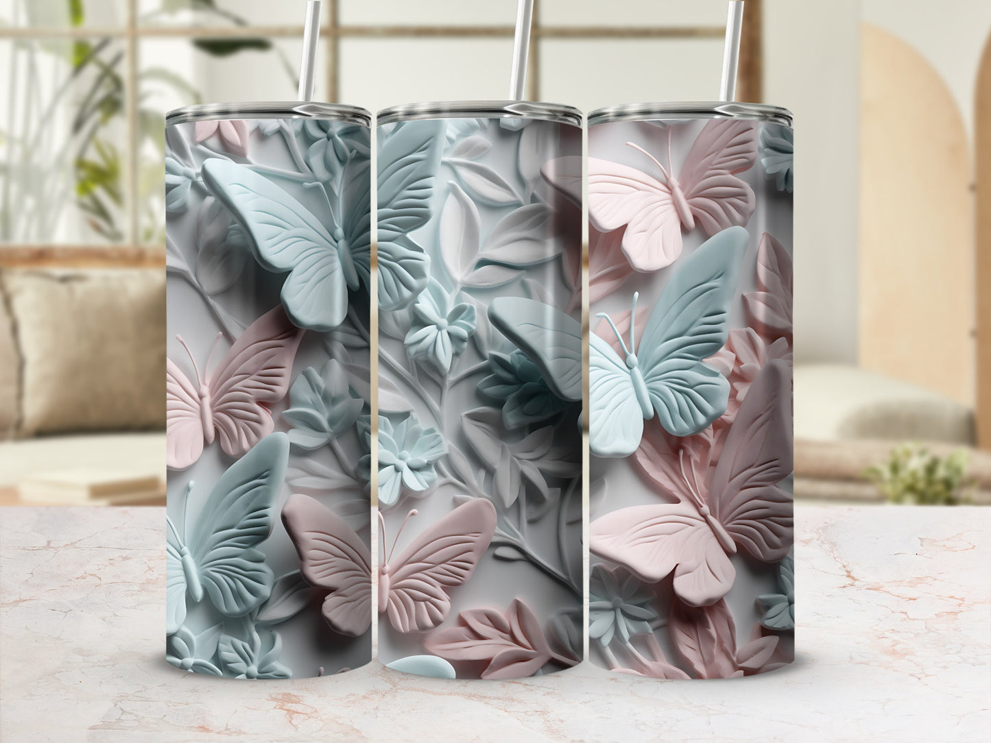 Three tumblers with embossed butterflies and floral designs in pastel colors.
